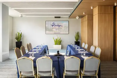 a conference room with a blue table and chairs at Rosslyn Central Park Hotel Sofia in Sofia
