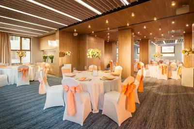 a banquet room with white tables and white chairs at Rosslyn Central Park Hotel Sofia in Sofia