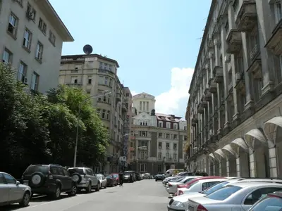 a city street with parked cars and buildings at Central Academic Apartment Sofia in Sofia