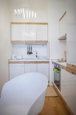 a white kitchen with a tub and a sink at Michelle Apartment in Sofia