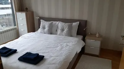 a bedroom with a bed with two blue towels on it at Michelle Apartment in Sofia