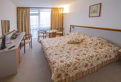 a bedroom with a bed and a table and chairs at Hotel Samokov in Borovets