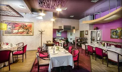 a restaurant with tables and chairs and purple walls at Alliance Hotel in Plovdiv