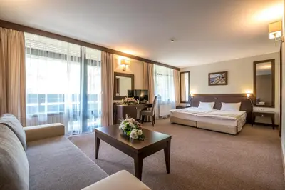 a living room with a couch and a bed and a table at Lion Hotel Borovets in Borovets