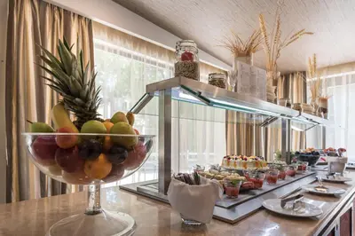 a buffet line with a bowl of fruit on a table at Lion Hotel Borovets in Borovets