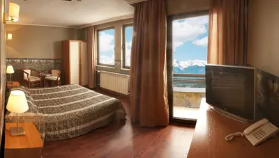 a hotel room with a bed and a large window at Aneli Hotel in Bansko