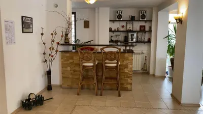 a kitchen with two bar stools and a counter at Aneli Hotel in Bansko