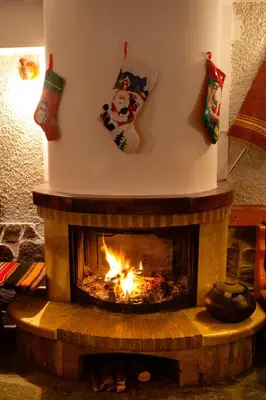 a fireplace with a christmas stocking hanging above it at Aneli Hotel in Bansko