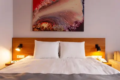 a bedroom with a bed with a painting on the wall at Best Western Terminus Hotel in Sofia
