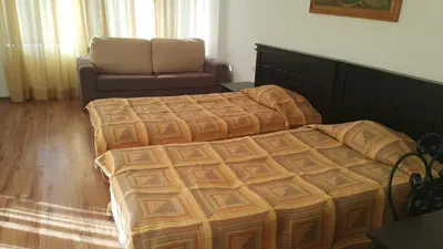 a bedroom with a bed and a chair and a couch at Hotel Via Trayana in Beli Osŭm