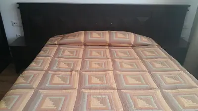 a bed with a brown bedspread on top of it at Hotel Via Trayana in Beli Osŭm