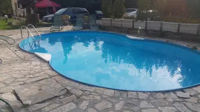 a blue swimming pool with chairs around it at Hotel Via Trayana in Beli Osŭm