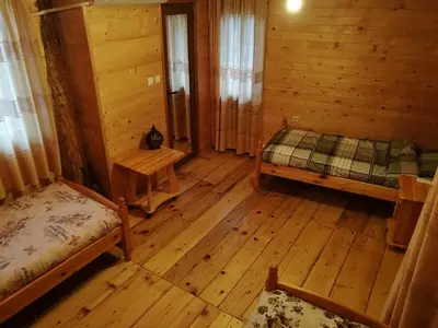 a room with two beds in a wooden cabin at Tree House in Sofia
