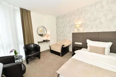 a hotel room with a bed and a chair at Art Plaza Hotel in Sofia