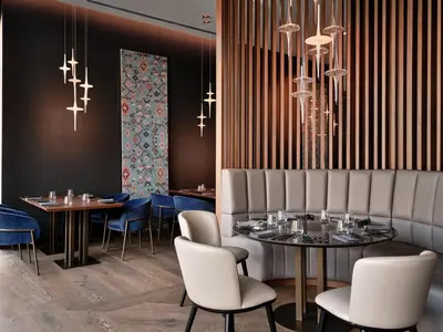 a dining room with tables and chairs and chandeliers at Crowne Plaza Sofia by IHG in Sofia