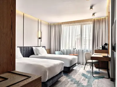 a hotel room with two beds and a desk at Crowne Plaza Sofia by IHG in Sofia