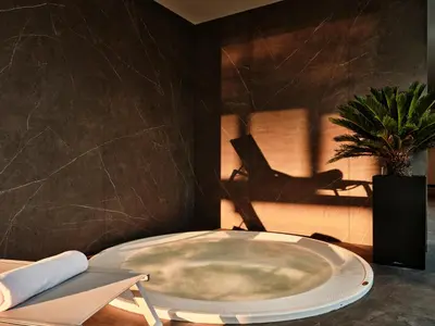 a bath tub in a room with a chair and a plant at Crowne Plaza Sofia by IHG in Sofia