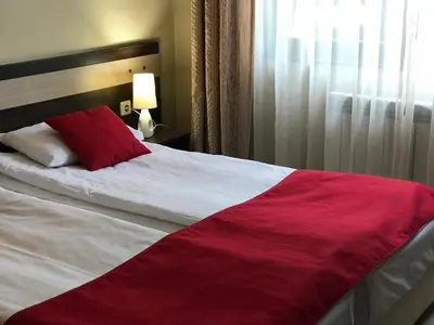 a red and white bed in a hotel room at Apart Hotel Dream in Bansko