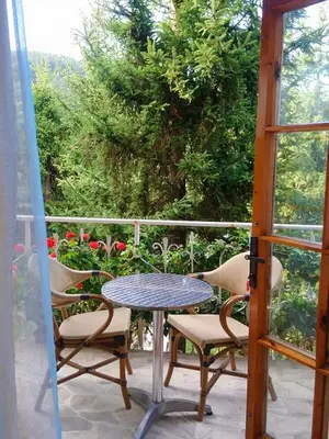 a table and chairs on a balcony with a window at Park Hotel Amfora -Free Parking in Sofia
