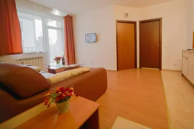a living room with a brown couch and a table at Apart Hotel Flora Residence Daisy in Borovets