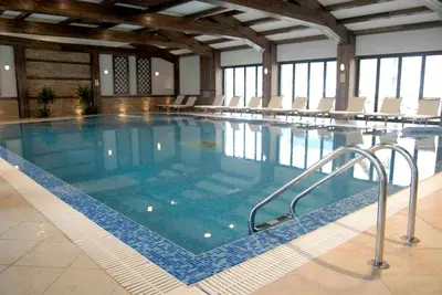 a large swimming pool with chairs in a building at Lion Bansko Hotel in Bansko