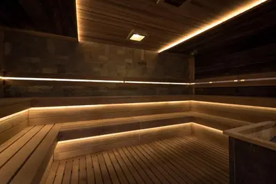 a sauna with a tub and lights in it at Lion Bansko Hotel in Bansko