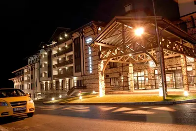a white car parked in front of a building at night at Lion Bansko Hotel in Bansko