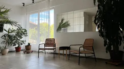 two chairs and a table in a room with plants at Hotel Gorna Banya in Sofia