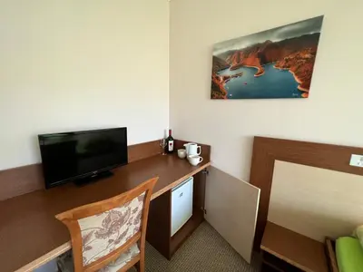 a room with a desk with a flat screen tv at Hotel Gorna Banya in Sofia