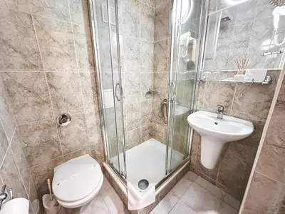 a bathroom with a shower and a toilet and a sink at Hotel Gorna Banya in Sofia