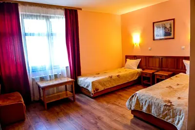 a hotel room with two beds and a window at Family Hotel Bansko Sofia in Sofia