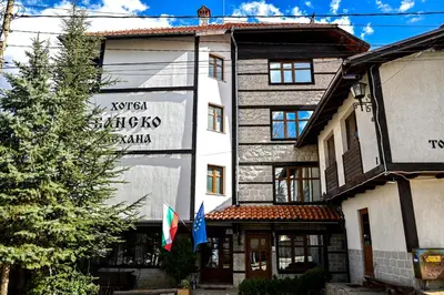 a building with two flags in front of it at Family Hotel Bansko Sofia in Sofia
