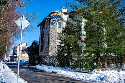 a building on the side of a street in the snow at Hotel Orphey in Bansko