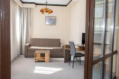a living room with a couch and a desk at Hotel Orphey in Bansko