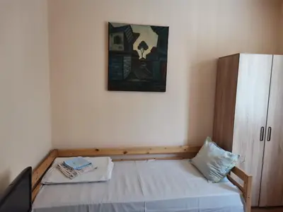 a small bedroom with a bed and a cabinet at Guesthouse Tzar Asen in Sofia