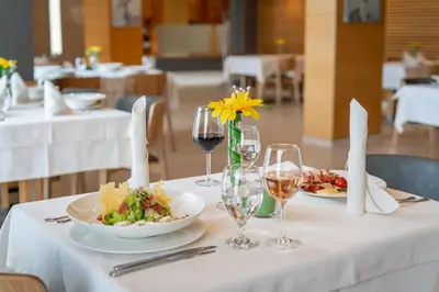 a table with plates of food and glasses of wine at Hotel ZOO Sofia in Sofia