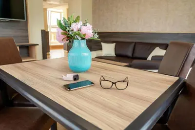 a table with a blue vase with flowers and glasses at Hotel ZOO Sofia in Sofia