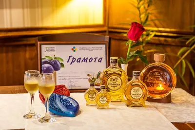 a table with two glasses of wine and a bottle of taronga at Chateau Montagne Hotel Troyan in Troyan