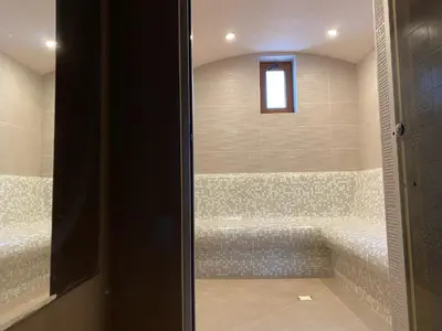 a bathroom with a tub with a window in it at Chateau Montagne Hotel Troyan in Troyan