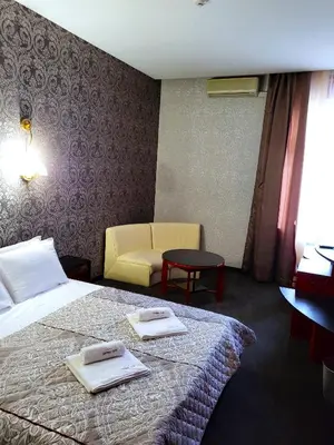 a hotel room with a bed and a chair at Hotel Central Club Sofia in Sofia