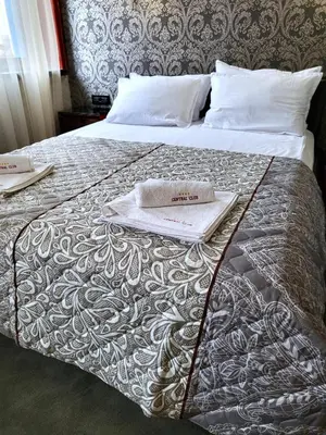 a bed with two towels on top of it at Hotel Central Club Sofia in Sofia