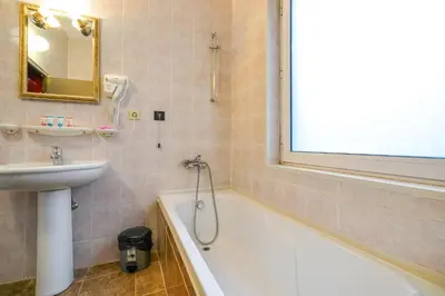 a bathroom with a bath tub and a sink and a bath at Hotel Central Club Sofia in Sofia