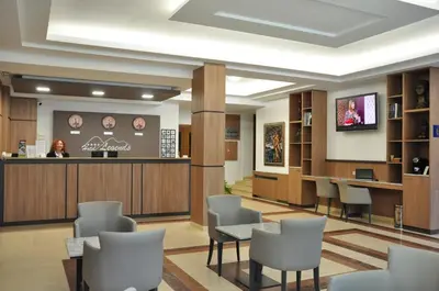 a waiting room at a clinic with a woman at the counter at Legends Hotel in Sofia