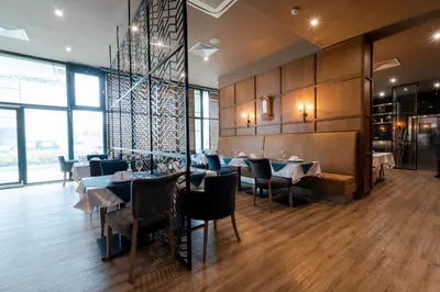a dining room with tables and chairs and windows at Vitosha Park Hotel - Free Pool & Parking in Sofia