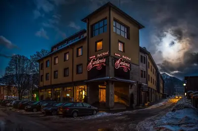 a building with cars parked in front of it at Gardenia Park Hotel in Bansko