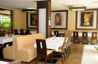 a dining room with white tables and chairs at Gardenia Park Hotel in Bansko