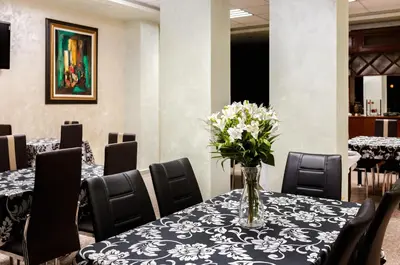 a vase of flowers on a table with chairs at Hotel Gabi in Plovdiv