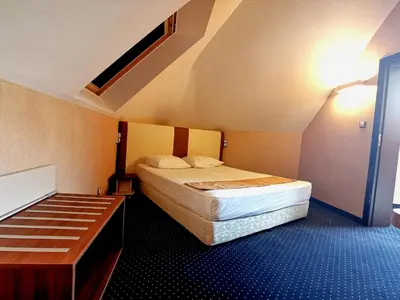 a small bedroom with a bed and a desk at Elate Plaza Hotel in Sofia