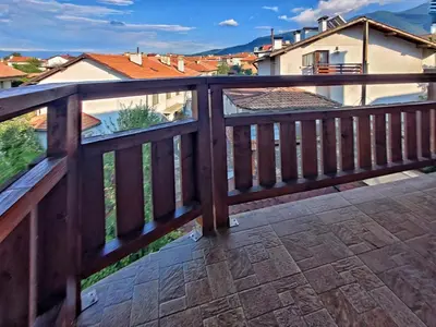 a wooden balcony with a view of a house at Kralev Dvor Hotel in Bansko