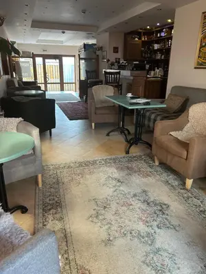 a living room with chairs and tables and a rug at Kralev Dvor Hotel in Bansko
